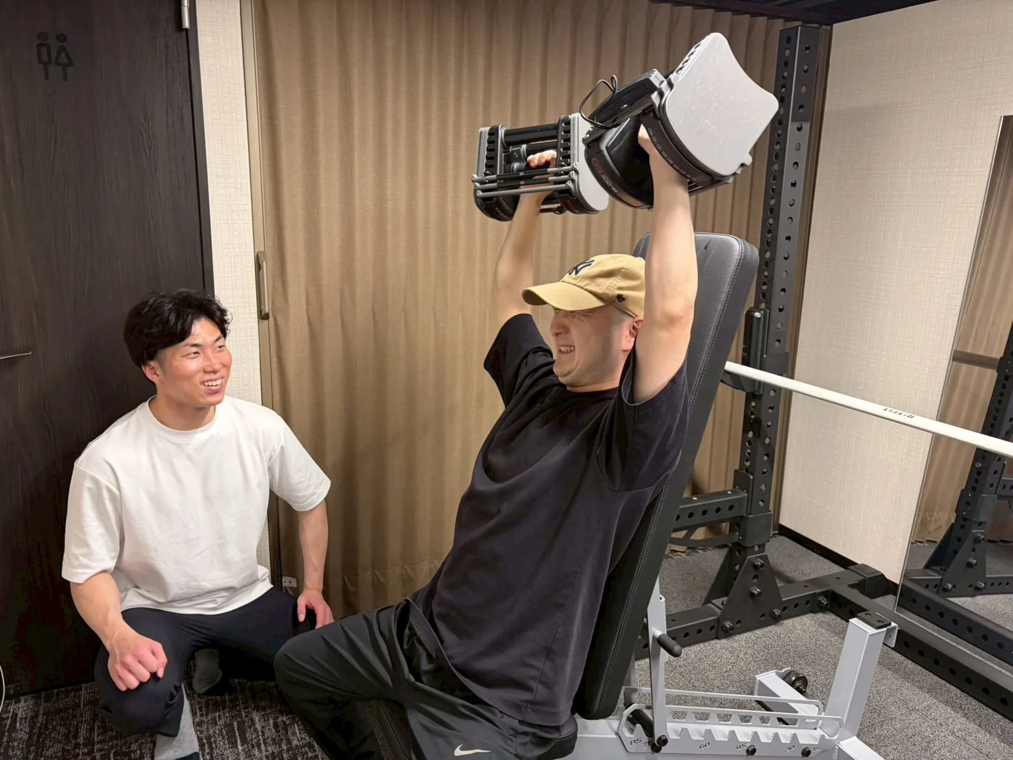 肩のトレーニングをトレーナーが見守っている様子