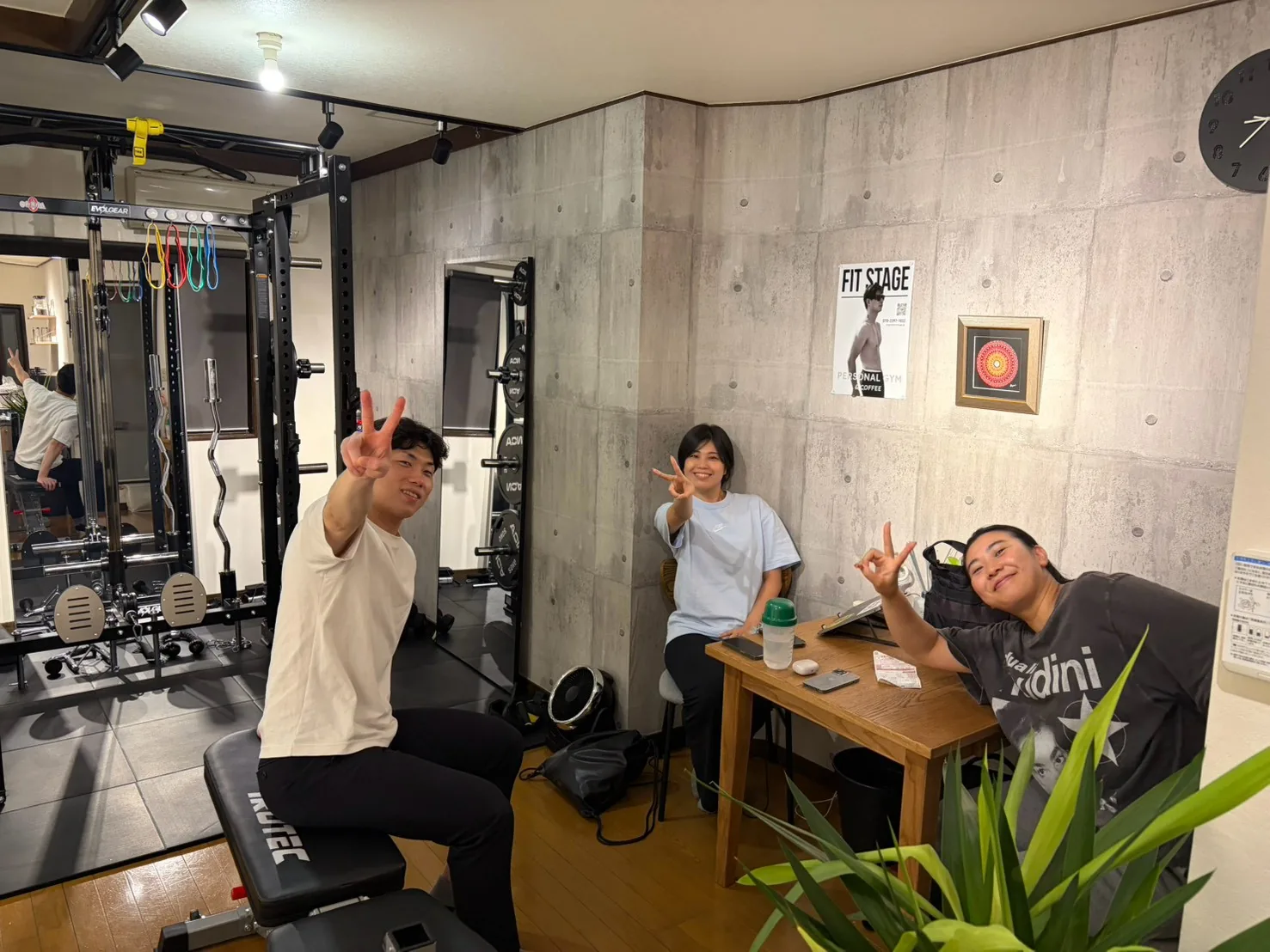 FIT STAGE江坂店のトレーニングルームで、笑顔でピースサインをする3人